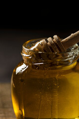 Fototapeta na wymiar a jar of honey with a honey spoon on a wooden board