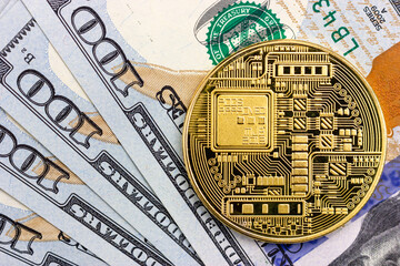 Bitcoin coin on the background of one hundred dollar bills. Blockchain technologies.