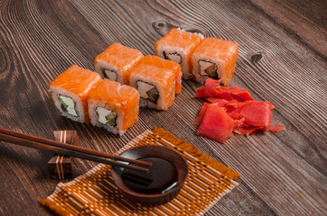 Sushi with chopsticks on a dark wooden table