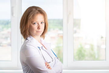 doctor or nurse stands at the window in medical clinic,smiling,health and medicine