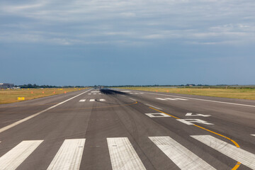 runway of airport with cloudy sky