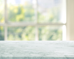Selective focus.Marble table top on blur window glass background.