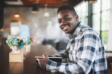 African man reading a book in coffe shop with smile and happy