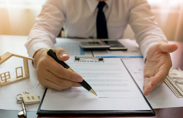 Fototapeta premium Bank officer or house seller agents showing point signature on the house purchase agreement. Real estate concept.