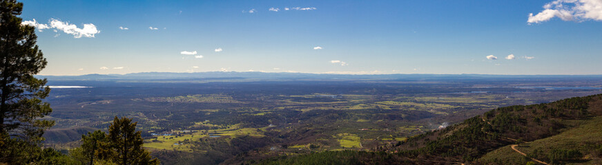 Panoramic view of a valley between mountains at sunset. Amplitude. Landscape. Pine forest.