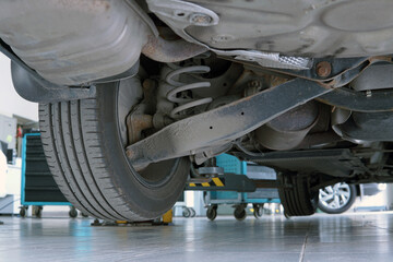 Modern car in a car service on a lift. Bottom view of the rear suspension of the car. Selected...
