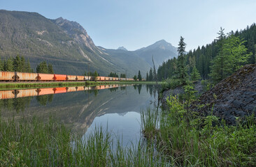 Freight train and pond in Yoho National Park near Field, British Columbia