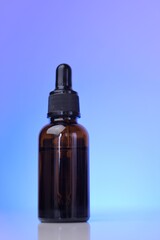 Organic natural oils. Serum for face skin. Natural bio cosmetics concept. glass brown bottle on a blue background.Cosmetic Mockup . Face serums in brown glass bottles in blue light.copy space.