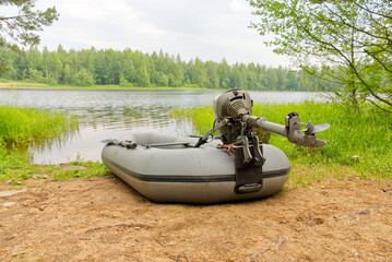 Rest and fishing in nature. A picturesque place on the lake. A car, an inflatable boat on the shore...