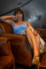portrait of attractive woman relaxing on a leather chair in a pub