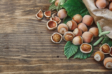 hazelnuts with green leaves on a wooden surface