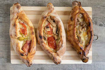 Peinirli with different flavours baked and ready to serve. Greek open faced pizzas on wooden...