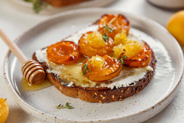 bruschetta with baked apricot, cottage cheese, thyme and honey. on white background. atmosphere of morning and breakfast