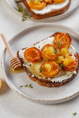 bruschetta with baked apricot, cottage cheese, thyme and honey. on white background. atmosphere of morning and breakfast
