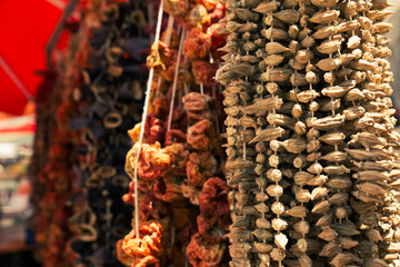 Dried okras and other vegetables in display under natural sunlight, outdoors.