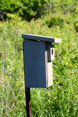 A close side view of the wood birdhouse in the park.