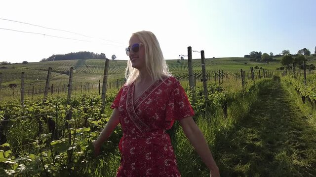 Lifestyle carefree woman on travel vacation by the vineyard terraces. Panoramic landscape at sunset in Hallau town of canton Schaffhausen in Switzerland. SLOW MOTION