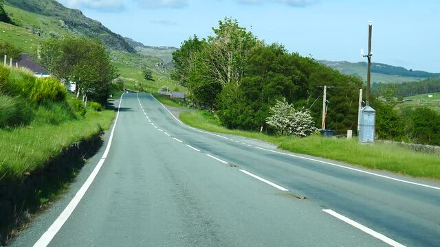 Car point of view, POV driving A4086 road in stunning rural scenery of Snowdonia on a nice summer day.