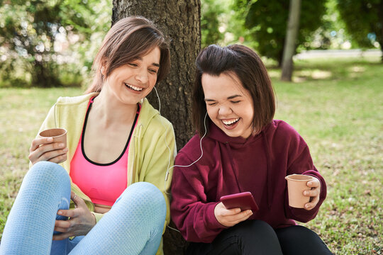 Girls laughing out loud and turning on songs at her smartphone