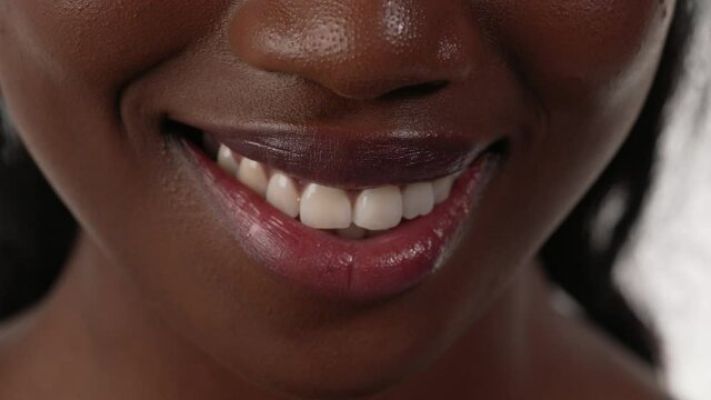 Close up of an african woman's mouth, biting her lips.