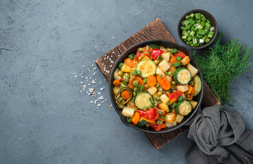Vegetable stew in a frying pan on a gray background with space for copying.