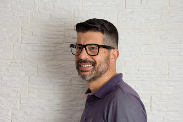 Portrait of Happy mature gray beard man with glasses half profile looking to the side.