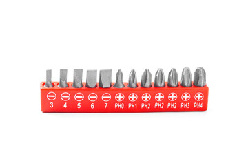 A variety of replaceable nozzles for screwdriver bits in a red plastic bag. Close-up on a white...