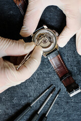 Watchmaker repairing an old wristwatch, top view