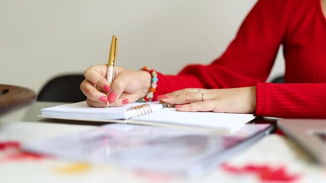 mujer latina senatada en la mesa de su hogar, haciendo negocios desde su laptop