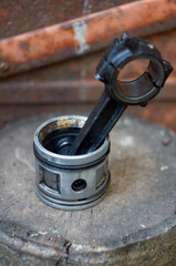 Photo of piston with a connecting rod on a stump