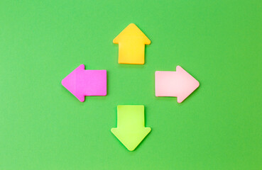 Green background with colorful arrow signs. The concept of choosing a path or direction.