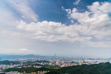 Overlooking view of the modern urban landscape of the Taipei area in Taiwan. It's a basin terrain surrounded by mountains.