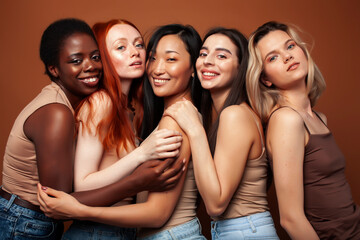 young pretty caucasian, afro, asian, scandinavian woman posing cheerful together on brown background, lifestyle diverse nationality people concept
