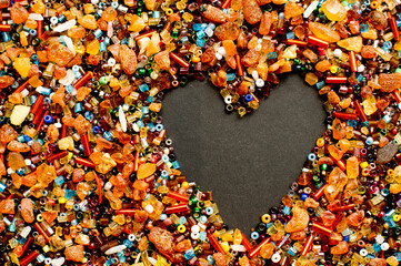 Love, Valentine theme, heart, relations. A mix of real amber and spun beads on black paper.