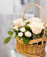 Wicker basket with white roses. Gift bouquet.