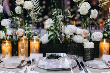 Romantic Wedding Table Top Layout Decor with large lush floral bouquets including white roses, ranunculus, persian buttercups, white orchids and candles