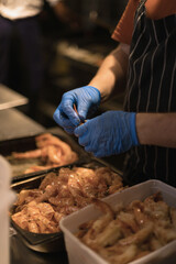 chef peeling shrimp with blue gloves