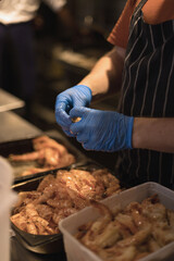chef peeling shrimp with blue gloves