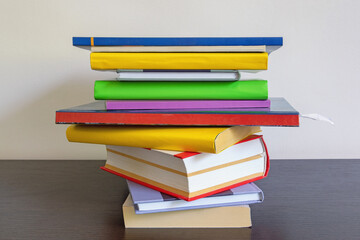 School concept. Stack of colorful  books on dark table. Free space for text