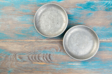 Old metal plates for scales on wooden background.