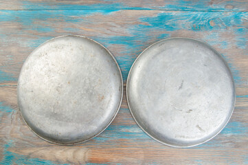 Old metal plates for scales on wooden background.