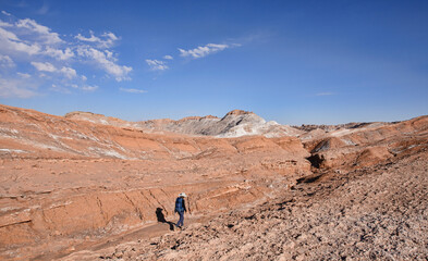 Fototapeta na wymiar Trekking through the desert landscape in the Moon Valley, San Pedro de Atacama, Chile
