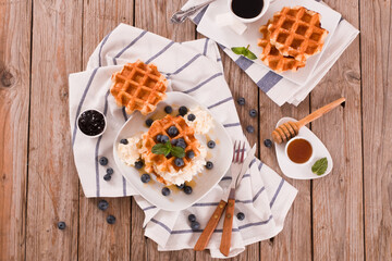 Waffles with blueberries and whipped cream.