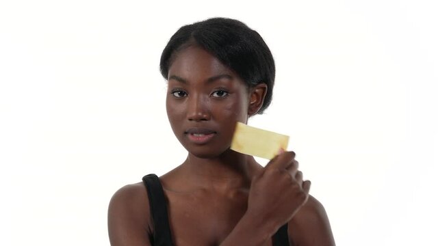 Portrait of an African woman, taking off tape from her mouth. White background.