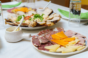 table cold cuts cheeses sliced chicken breast garnishes