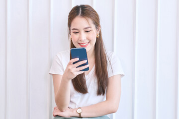 Photo of cheerful cute beautiful young woman chatting by mobile phone