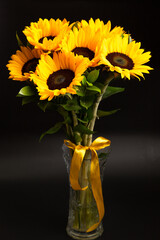 Bouquet of bright sunflowers against black background
