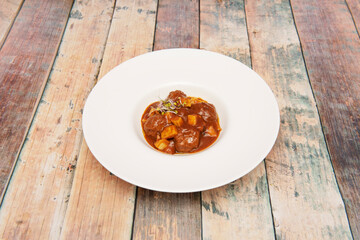 Great meatloaf stew cooked with grandma's recipe on a white plate and bean sprouts on top