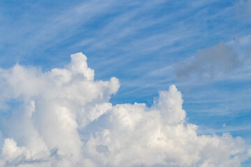 Naklejka na ściany i meble White curly cloud close up in the blue sky