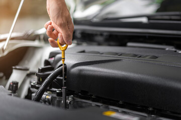 Close up of hands checking the oil level in the engine before a trip or journey, Car check condition concept.